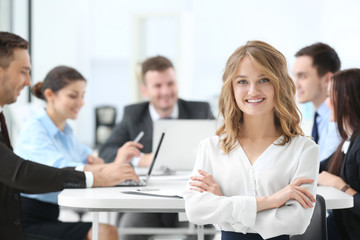 Canvas Print - Businesswoman with colleagues on background at office