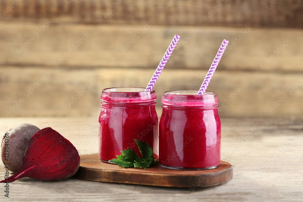 Fresh beetroot smoothie and vegetables on wooden wall background
