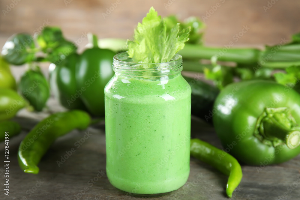 Glass jar with vegetable smoothie on wooden table