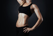 © lkoimages - Muscular fitness woman posing on a dark background