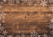 Winter Hintergrund für Weihnachten mit Schneeflocken / Eiskristallen auf rustikalem Holz
