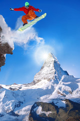 Snowboarder jumping against Matterhorn peak in Switzerland