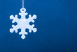 Cute white safety reflector in the form of snowflakes on blue background. Necessary equipment to pedestrians for walks during dark conditions.