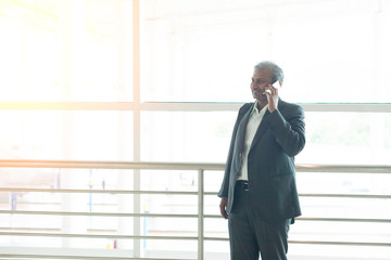 senior indian business male with phone conversation