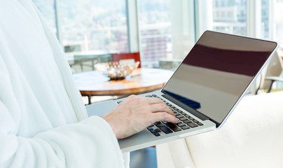 Wall Mural - Man in a bathrobe on a laptop in a bright room