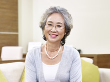 Portrait Of Senior Asian Woman Sitting On Couch At Home