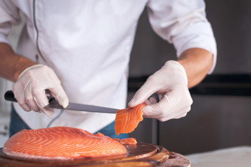 Chef cutting fresh salmon