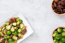 Brussels Sprouts With Chestnuts And Bacon On White Marble

