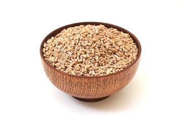 Spelt grain (dinkel wheat) in wooden bowl isolated on white background