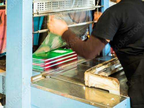 Fotografia, Obraz Asian women coating plastic for book make it ready to pack in bo