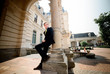 © IVASHstudio - young and handsome groom in black suit standing near manor