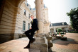 © IVASHstudio - young and handsome groom in black suit standing near manor