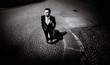 © IVASHstudio - young and handsome groom in black suit standing on the pavement