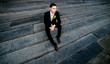 © IVASHstudio - young and handsome groom in black suit sitting on the stairs