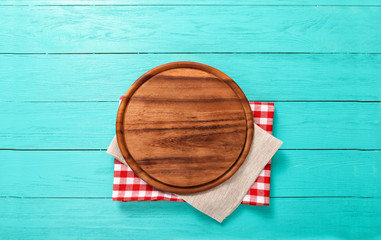 Wall Mural - Round cutting board on red plaid and gray tablecloth. Top view and copy space