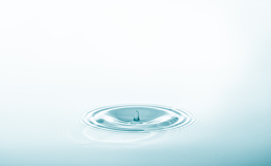 Wall Mural - water drop falling and drips on water mirror. water drop splash and make perfect circles on water su
