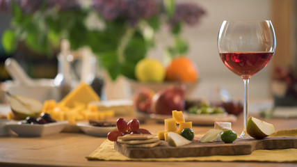 glass of red wine with a snacks stand on the kitchen table