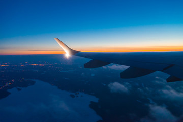 aircraft wing with light and winglet at dusk with frozen lake below 