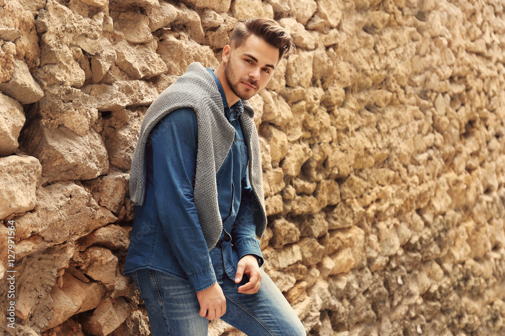 Handsome man near old building with brick wall
