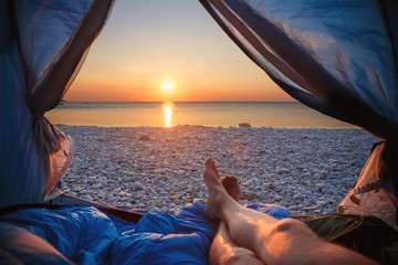 Image human legs lying in tourist tent