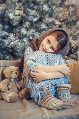  Cute little girl covered in warm scarf waiting for Christmas
