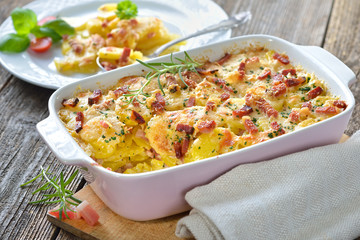 Kartoffelgratin mit Parmesan, Sahne und Südtiroler Speck frisch aus dem Ofen -  Potato gratin with parmesan cheese, cream and cured bacon from South Tyrol