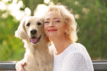 Wall Mural - Senior woman sitting on bench with dog, closeup