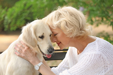 Wall Mural - Senior woman sitting on bench with dog, closeup