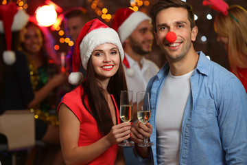 Young people with glasses of champagne at Christmas party