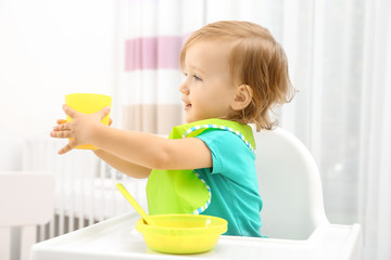 Poster - Cute little girl in high chair at baby room