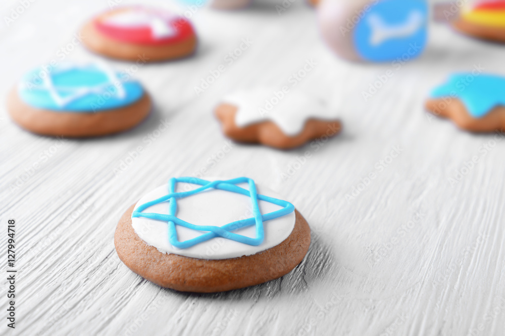 Tasty glazed cookie for Hanukkah on light wooden table, closeup
