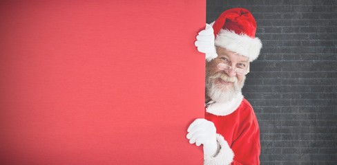 Poster - Composite image of santa claus peeking from red board