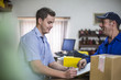 © Westend61 - Man in warehouse signing on document for purchase