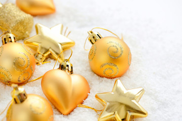 christmas gold ornaments on the snow. festive christmas background