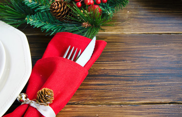 Wall Mural - Christmas table settings in red tone. Traditional  bunch of fir tree, red napkin with cutlery on rustic background. decoration for festive dinner Copy space