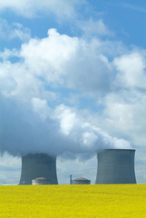 Nuclear Power Station with steaming tower over clear blue sky.