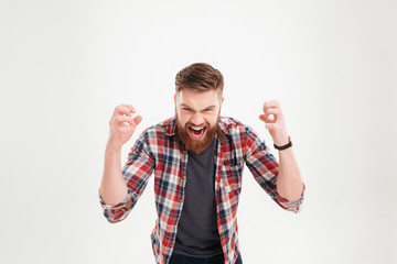 Portrait of a casual angry man screaming with raised arms