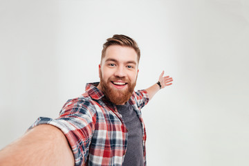 close up portrait of a cheerful bearded man taking selfie