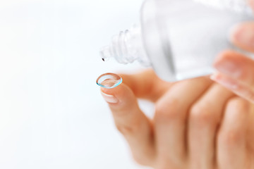 Woman Hand With Contact Eye Lens And Cleansing Solution