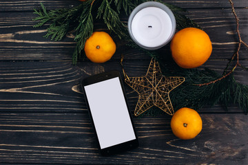 stylish christmas flat lay with green branches and oranges on bl