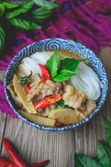 Wall Mural - Thai Green Curry with Pork on Thai Fabric and  Old Wooden Backgr