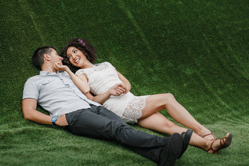 Wall Mural - couple in love lying on green artificial grass