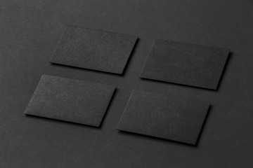 Wall Mural - Mockup of four black business cards arranged in rows at paper