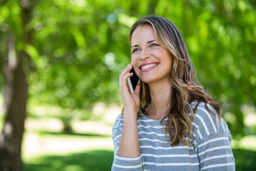 Wall Mural - Smiling woman making a phone call