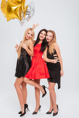 Three smiling women holding star shaped balloons and having fun