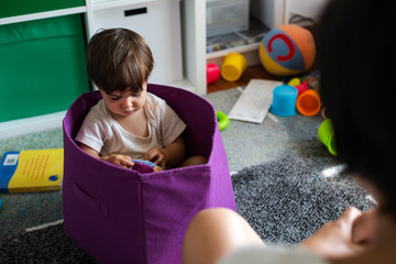 Niño jugando feliz  mientras su madre observa