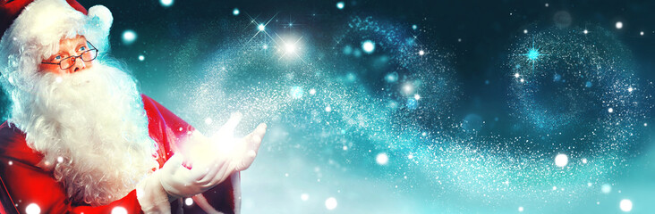 portrait of happy santa claus with magic light in his hands