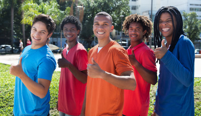 Group of five male young adults in line showing thumbs up