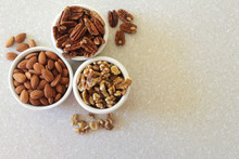 Almonds, Pecans, And Walnuts In Containers, Positioned Left