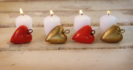 Poster - Burning candles with heart shape pendant on wooden plank